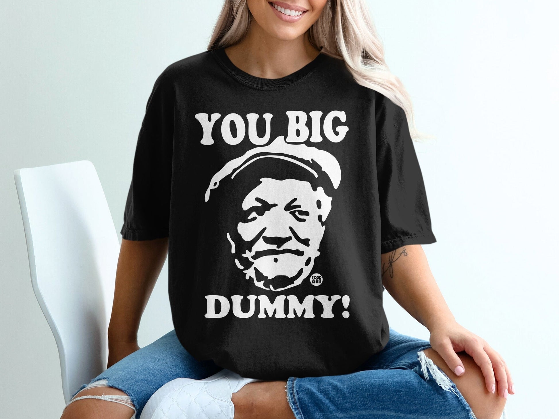 Black t-shirt with white text "YOU BIG DUMMY!" and a portrait.
