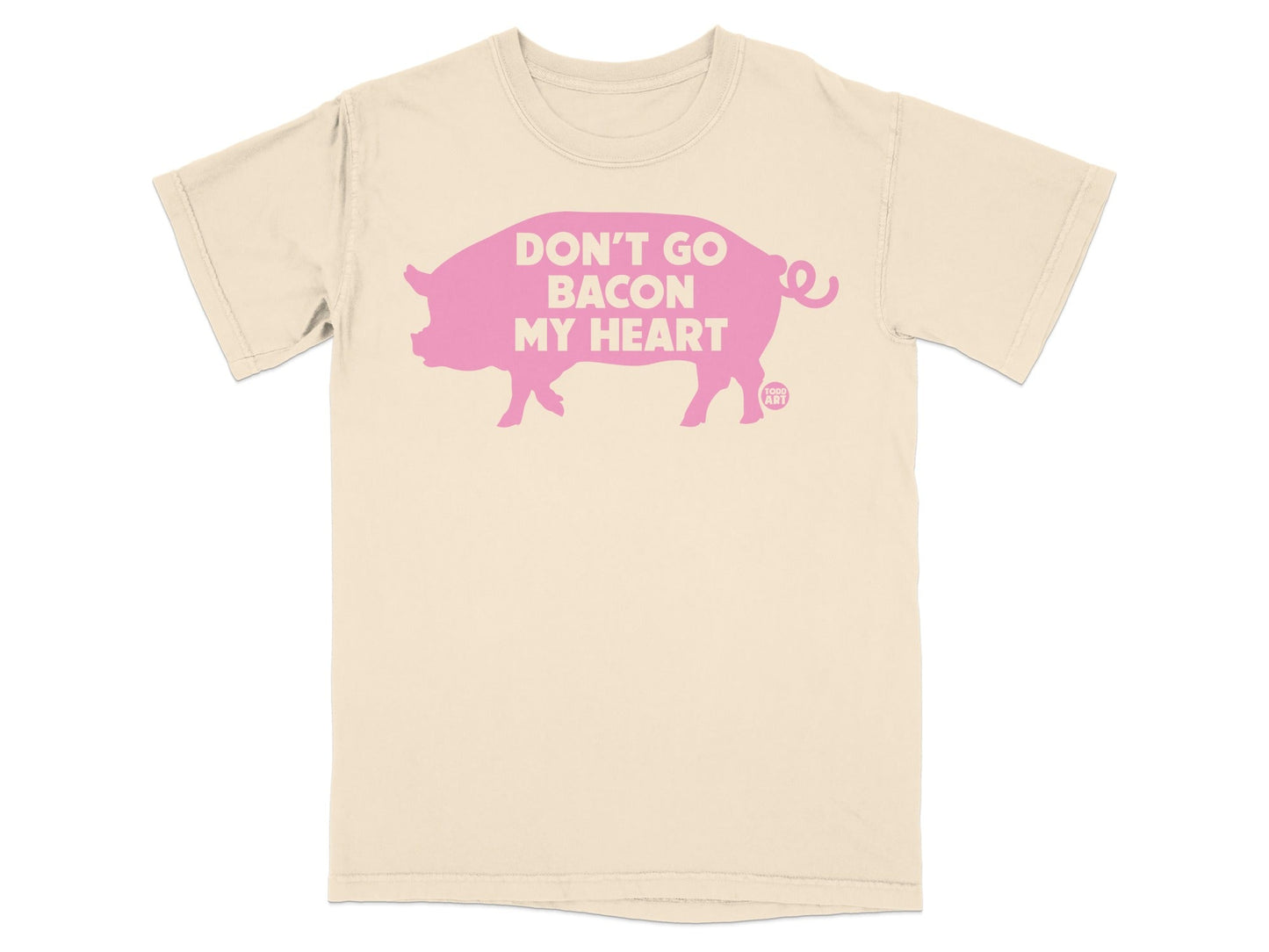 Cream t-shirt with a pink pig silhouette and text "DON'T GO BACON MY HEART".