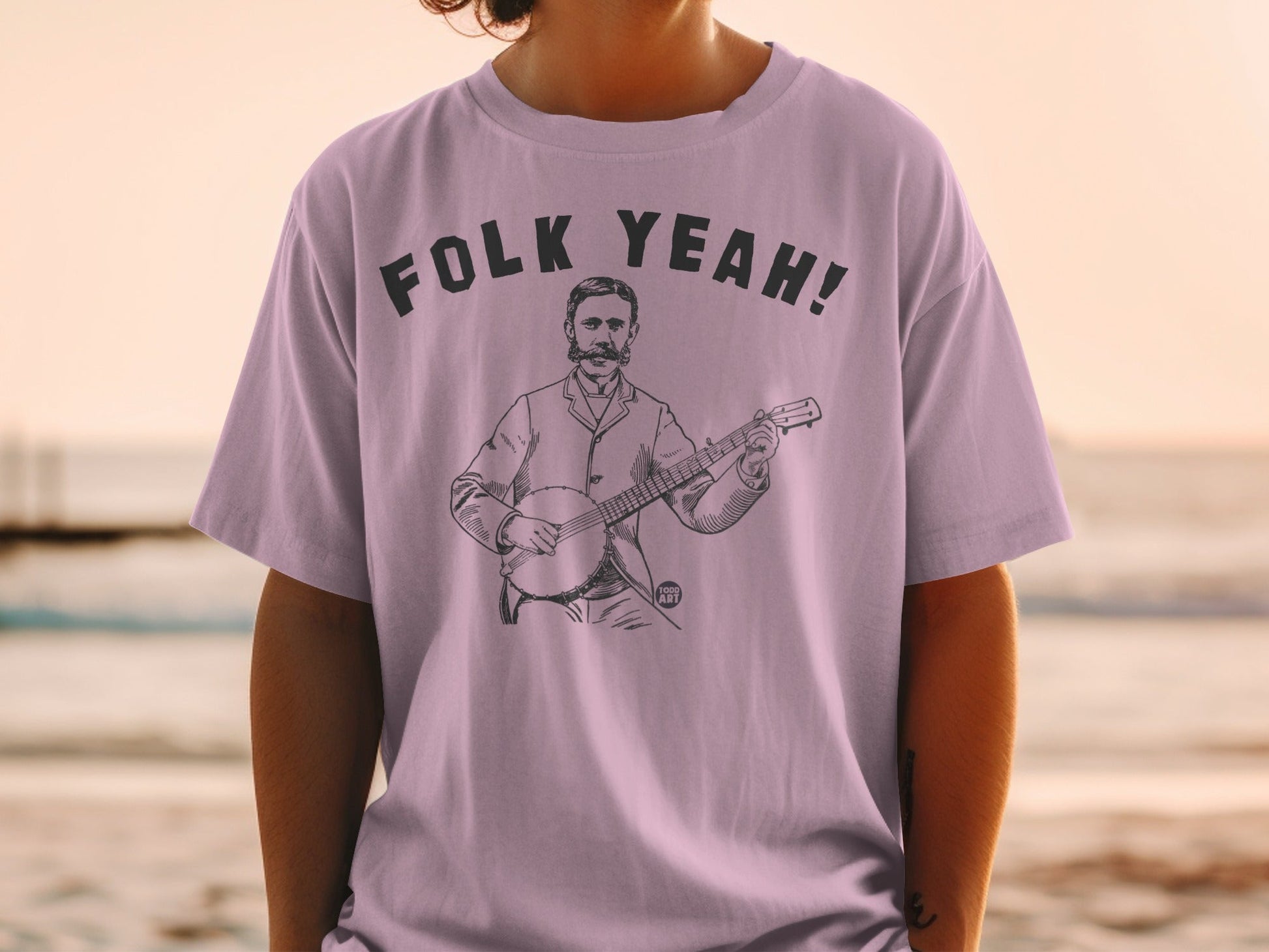 T-shirt with "Folk Yeah!" text and a drawing of a man playing a banjo.
