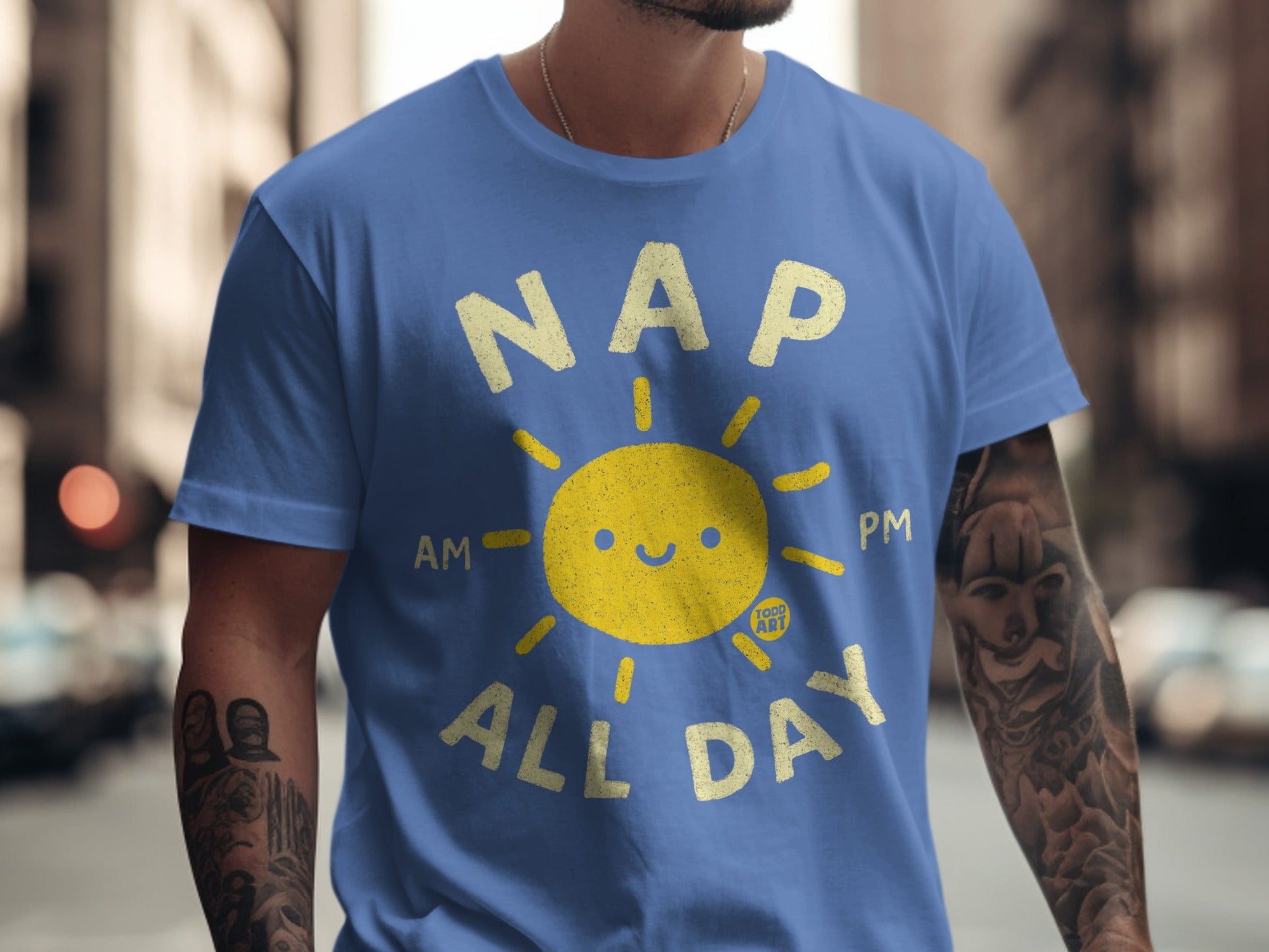 Blue t-shirt with yellow sun graphic and text "NAP AM PM ALL DAY".