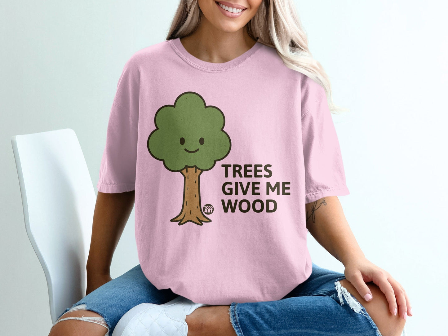 Pink t-shirt with cartoon tree and text "TREES GIVE ME WOOD".