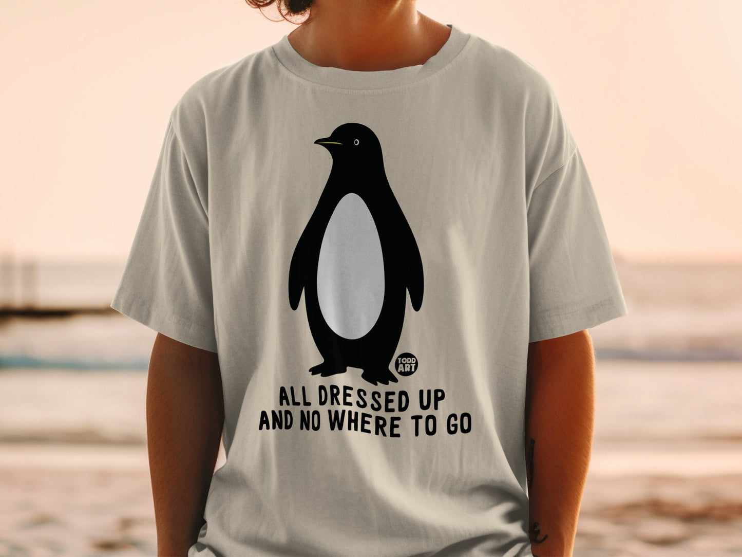 T-shirt with penguin graphic and text "ALL DRESSED UP AND NO WHERE TO GO".