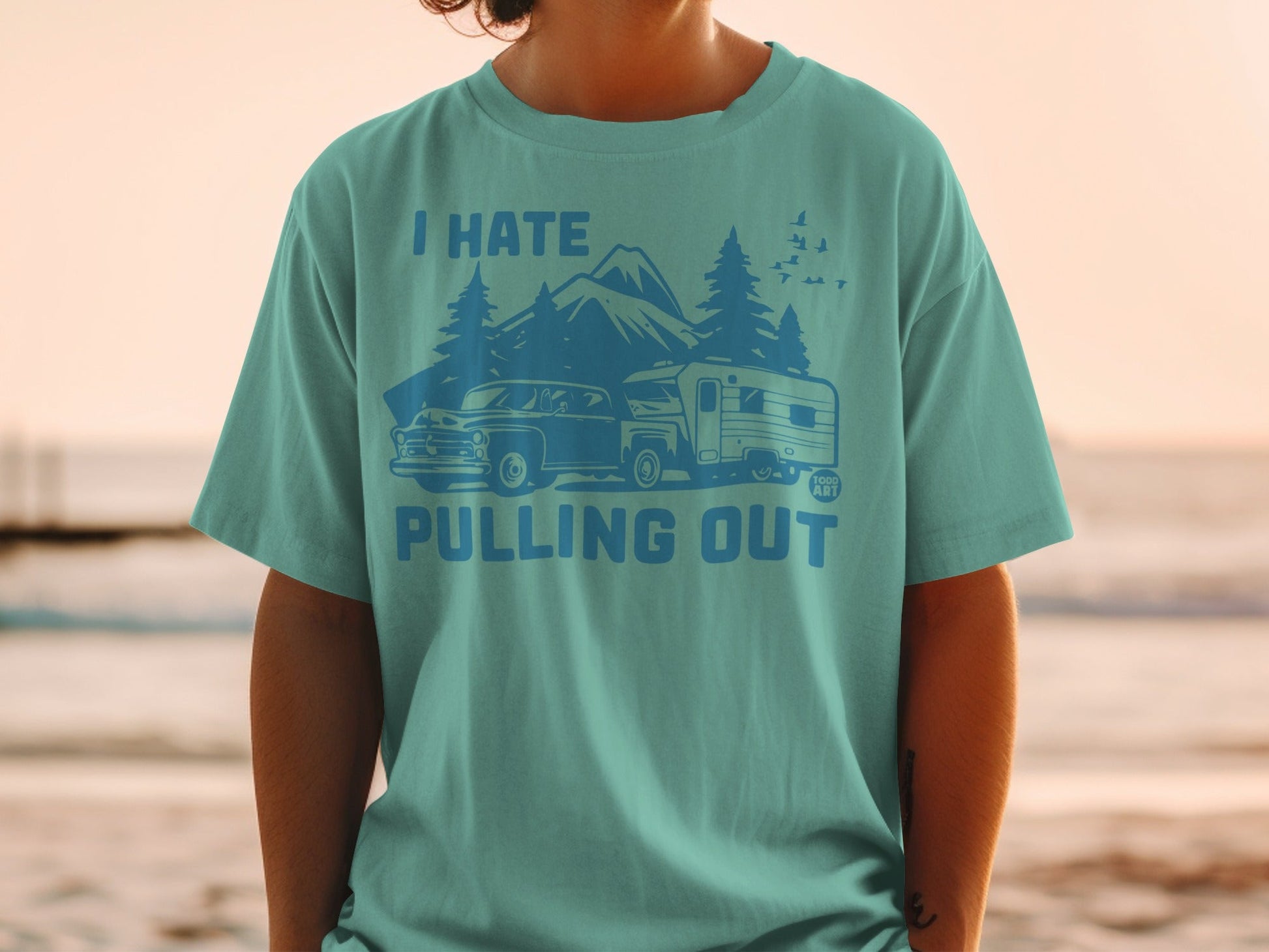 Teal t-shirt with graphic of vintage car and camper trailer, text reads "I HATE PULLING OUT".