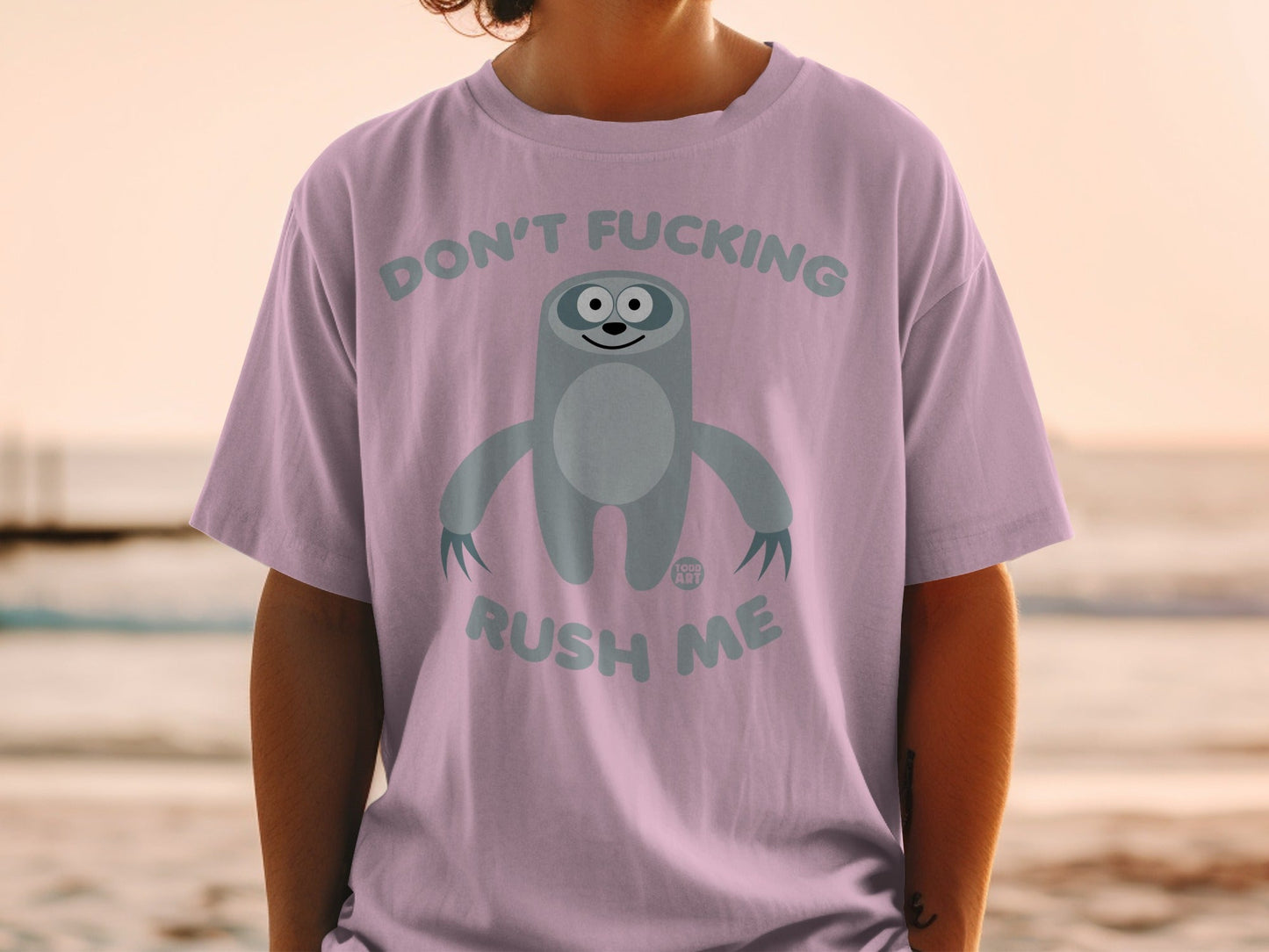 Pink t-shirt with a cartoon sloth and text "DON'T FUCKING RUSH ME".
