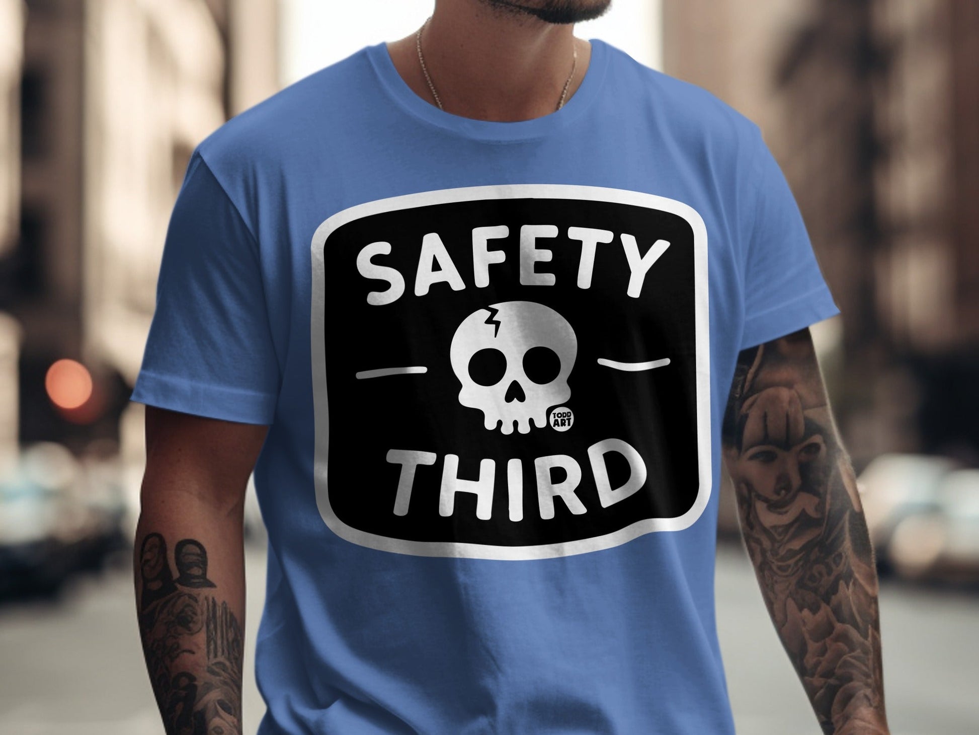 Blue t-shirt with a black and white "SAFETY THIRD" skull graphic.
