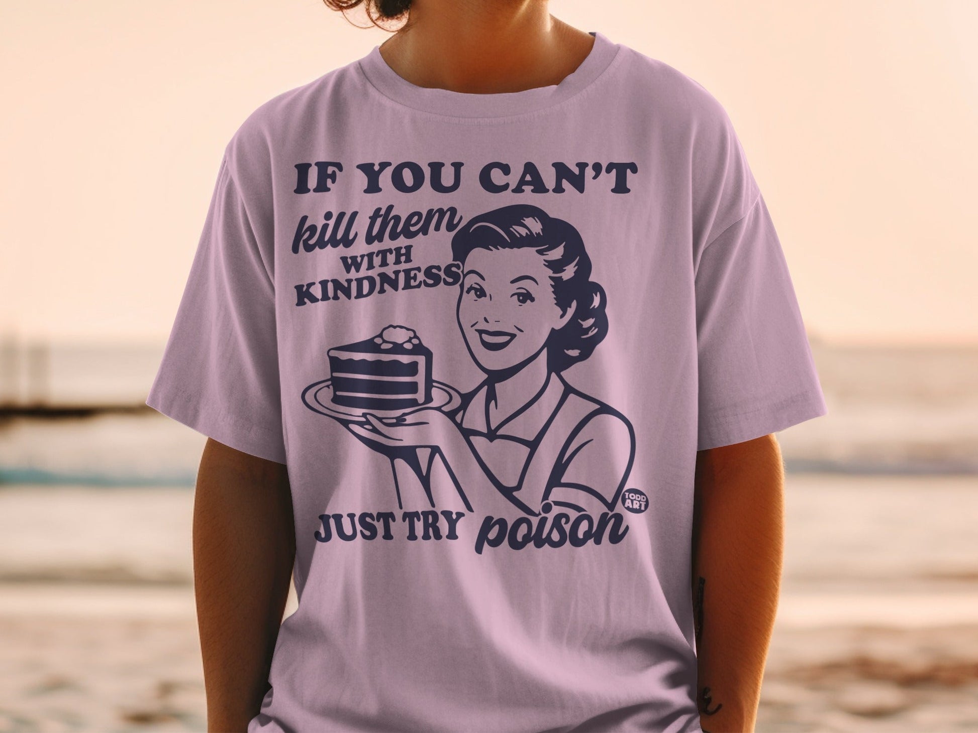 T-shirt with graphic: woman holding cake, text "IF YOU CAN'T kill them WITH KINDNESS JUST TRY poison"