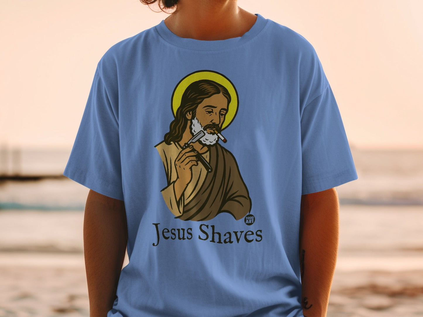 T-shirt with illustration of Jesus shaving with a razor, text "Jesus Shaves".