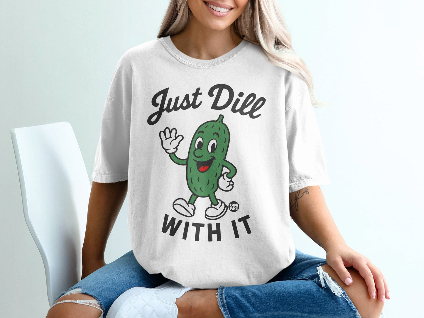White t-shirt with cartoon pickle and "Just Dill With It" text.