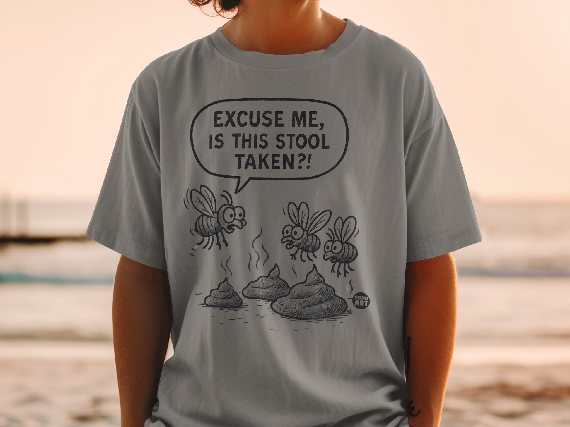 T-shirt with cartoon flies buzzing around piles of cartoon poop, text reads "Excuse me, is this stool taken?!"