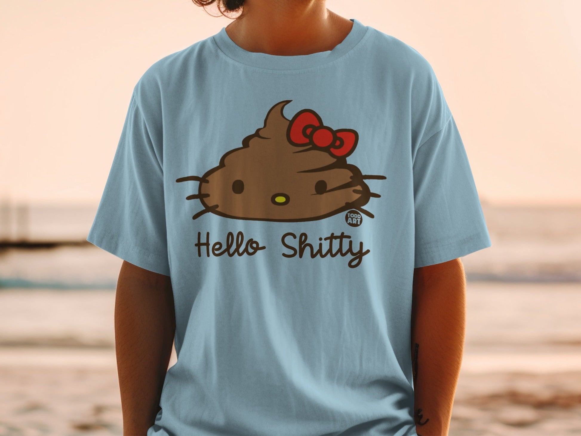 Light blue t-shirt with a cartoon Hello Kitty-style poop character and "Hello Shitty" text.