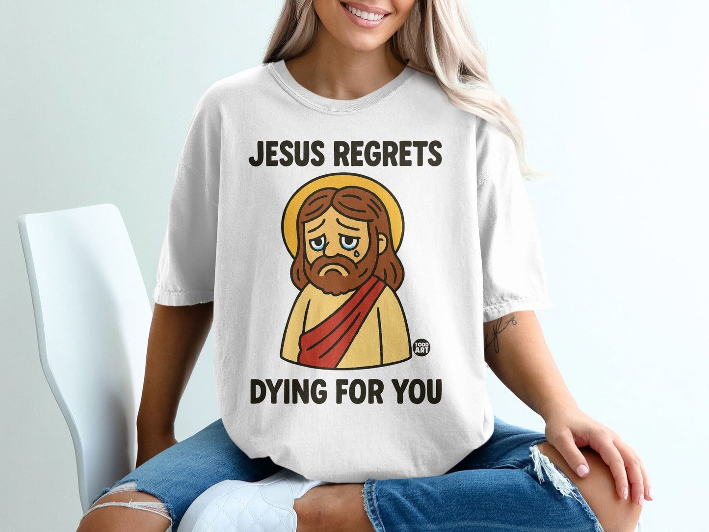 Jesus regrets dying for you graphic on a white t-shirt.