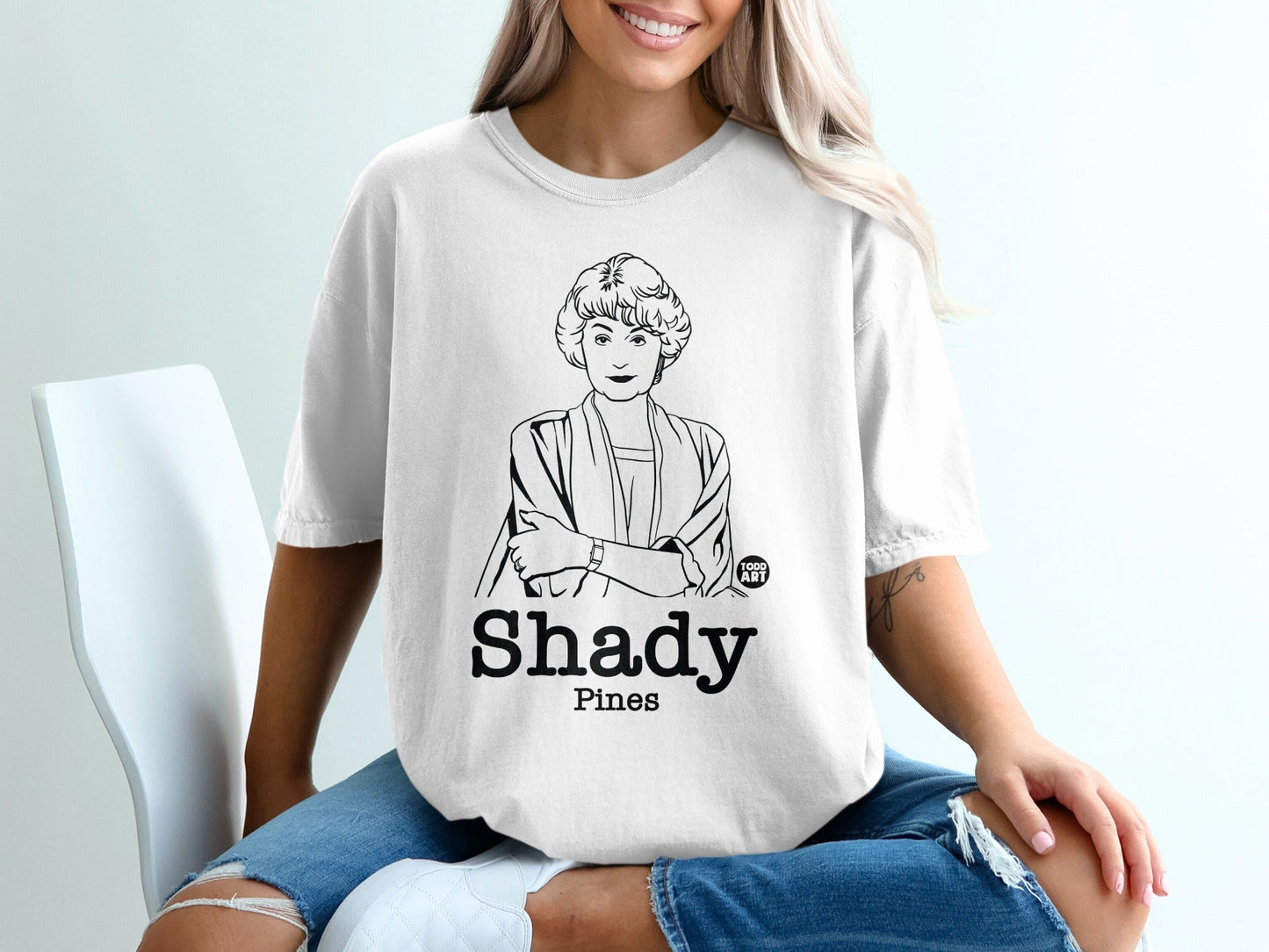 White t-shirt with black line drawing of Bea Arthur and "Shady Pines" text.