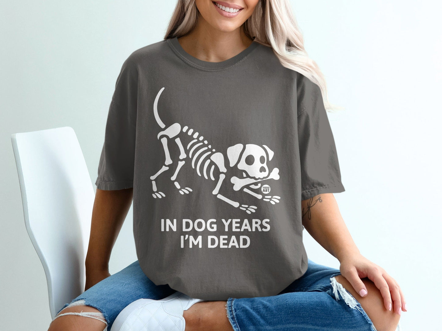 Dark grey t-shirt with a skeleton dog graphic and text "IN DOG YEARS I'M DEAD".