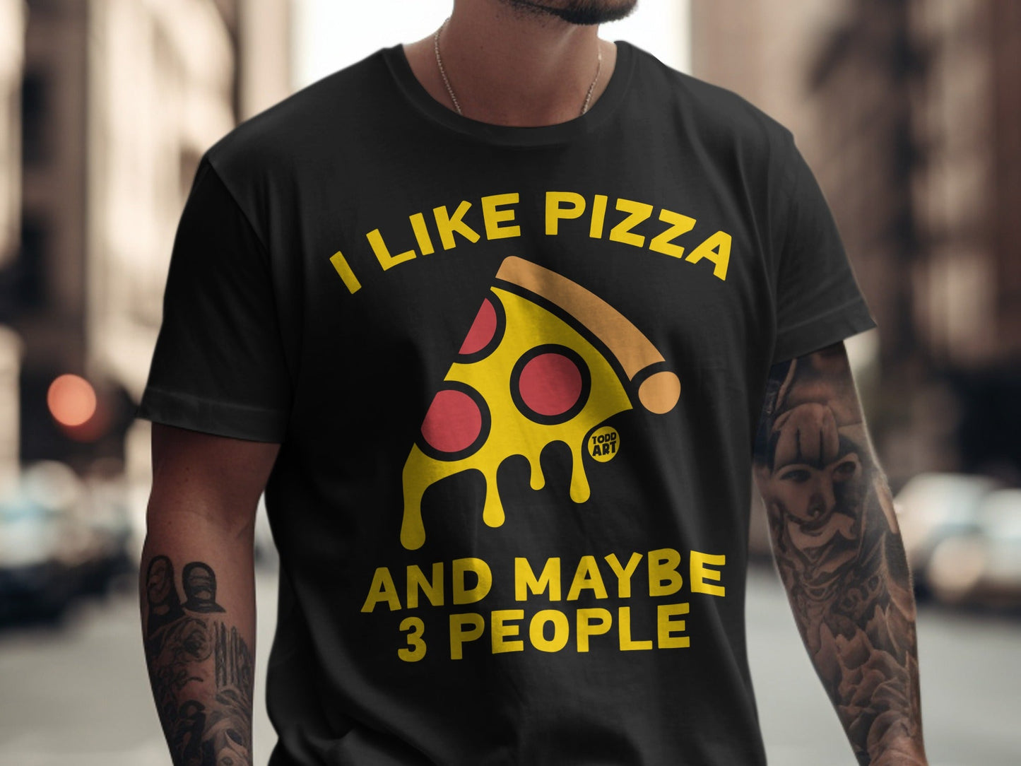 Black t-shirt with yellow text "I LIKE PIZZA AND MAYBE 3 PEOPLE" and a pizza slice graphic.