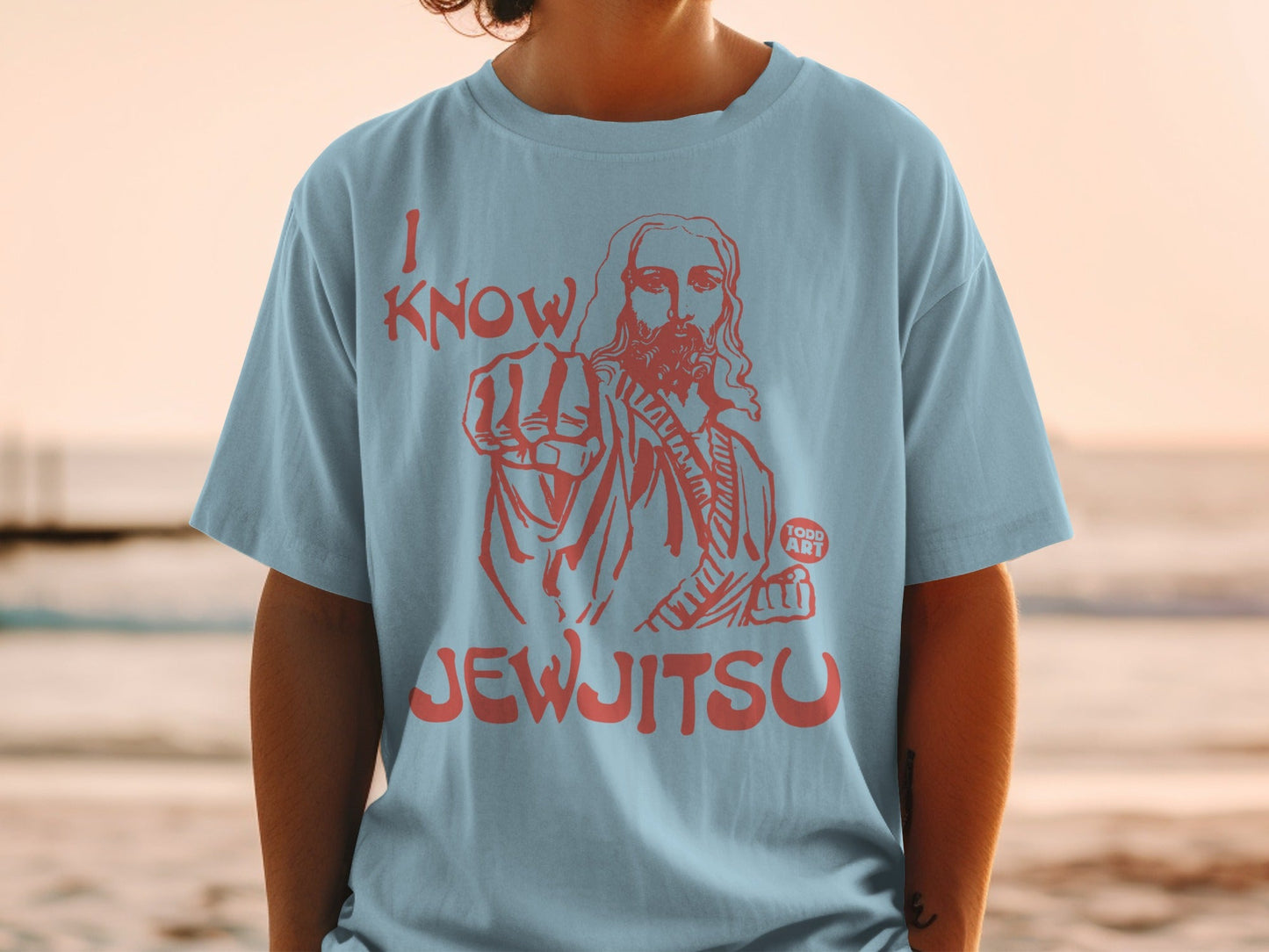 Light blue t-shirt with red text "I KNOW JEWJITSU" and image of Jesus pointing.