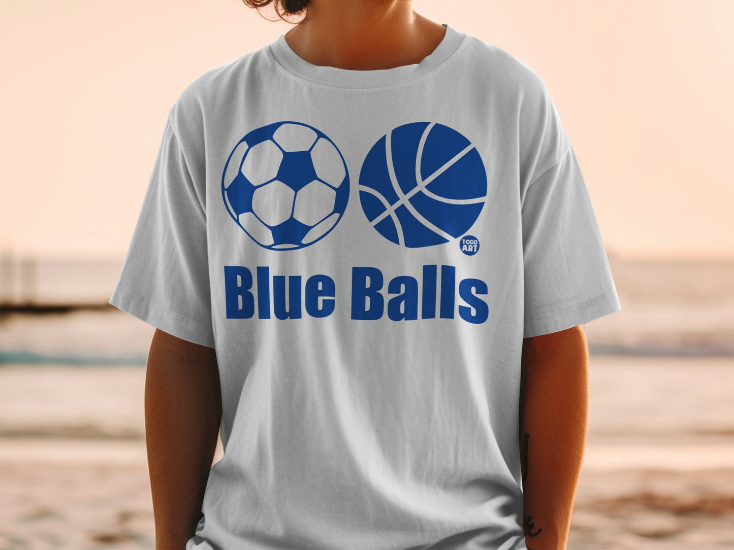 White t-shirt with soccer ball, basketball, and "Blue Balls" text.