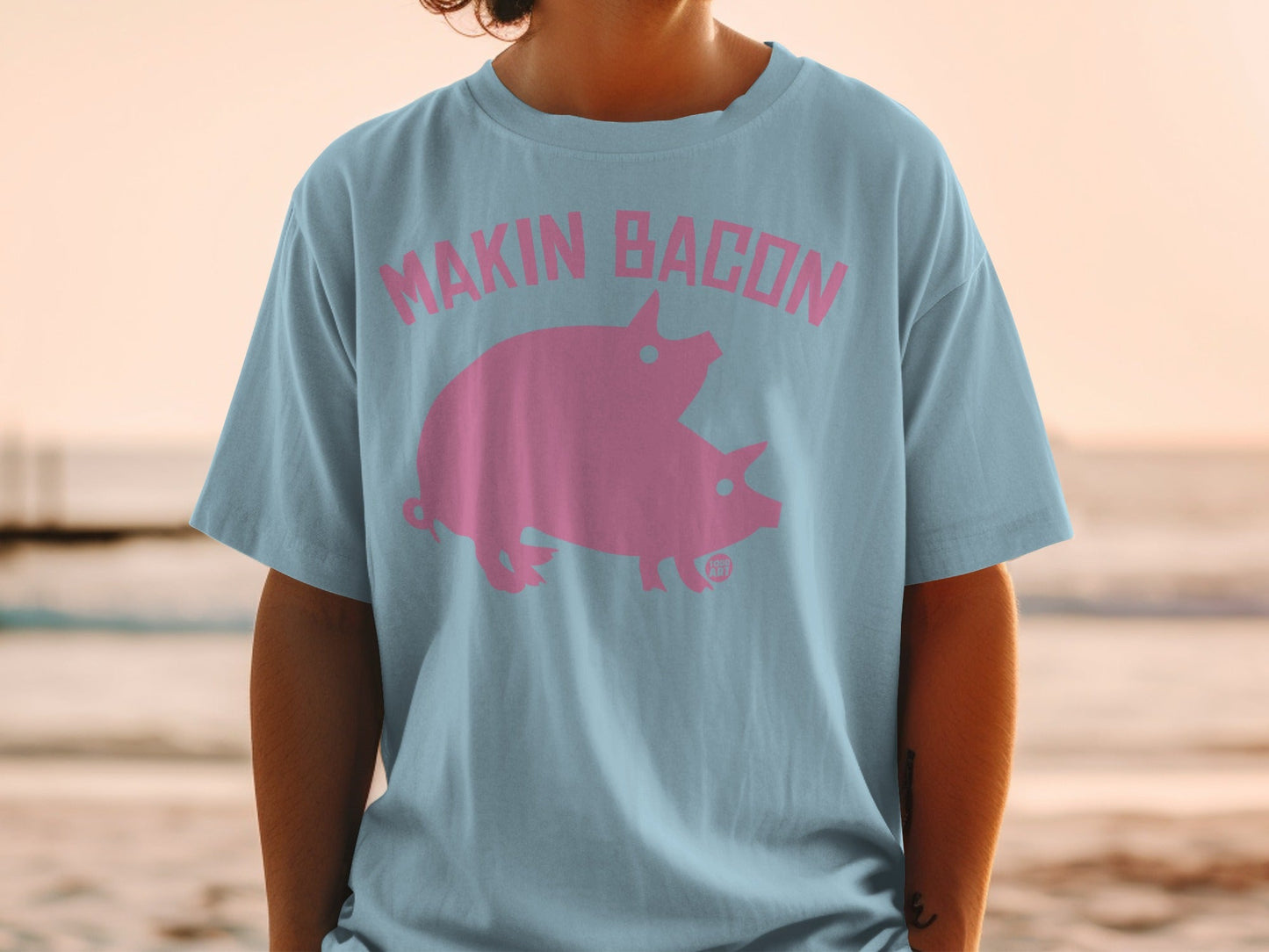 Light blue t-shirt with "MAKIN' BACON" and two pink pigs.