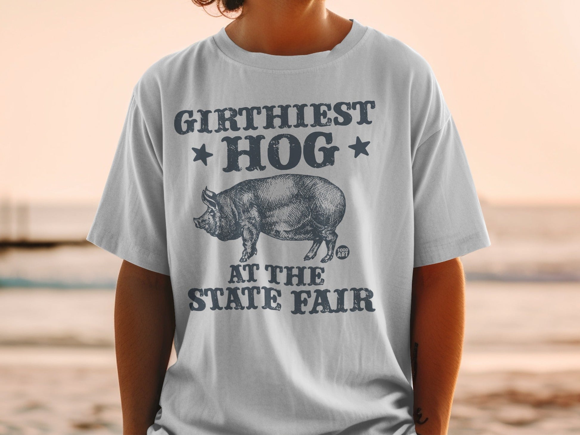 T-shirt with "GIRTHIEST HOG AT THE STATE FAIR" text and pig graphic.