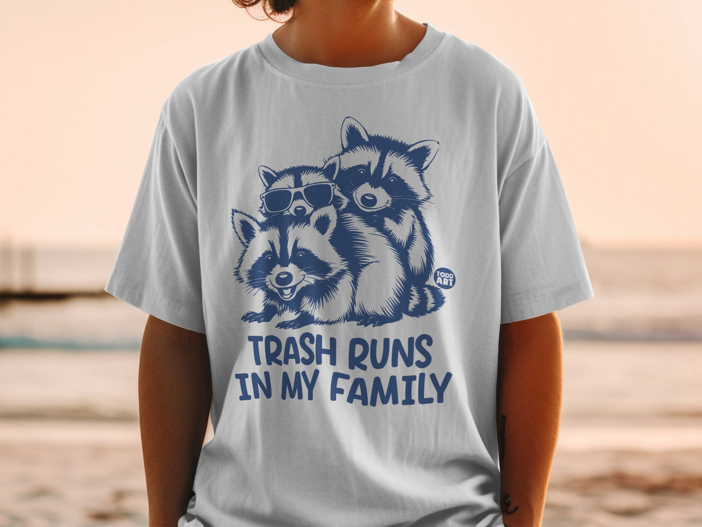 T-shirt with three raccoons wearing sunglasses and the text "TRASH RUNS IN MY FAMILY".