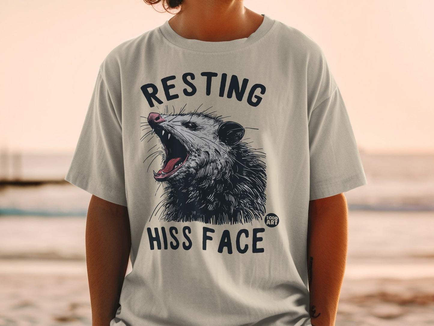 T-shirt with a possum graphic and text "RESTING HISS FACE."