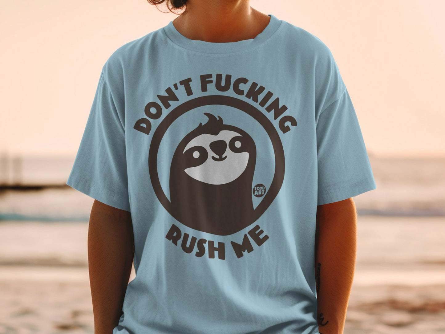 Blue t-shirt with a sloth graphic and the text "DON'T FUCKING RUSH ME".