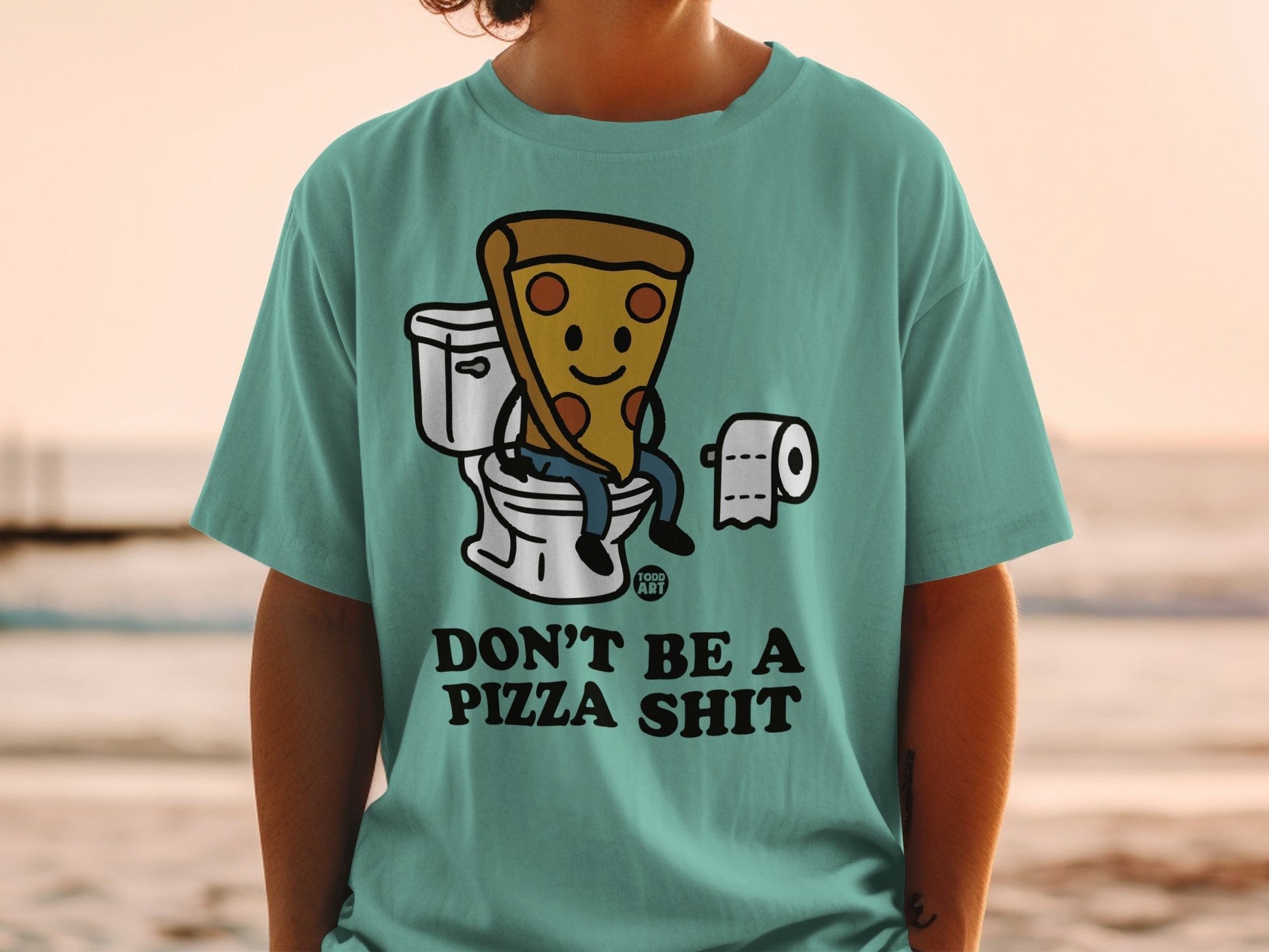 T-shirt with cartoon pizza slice sitting on a toilet, text "DON'T BE A PIZZA SHIT".