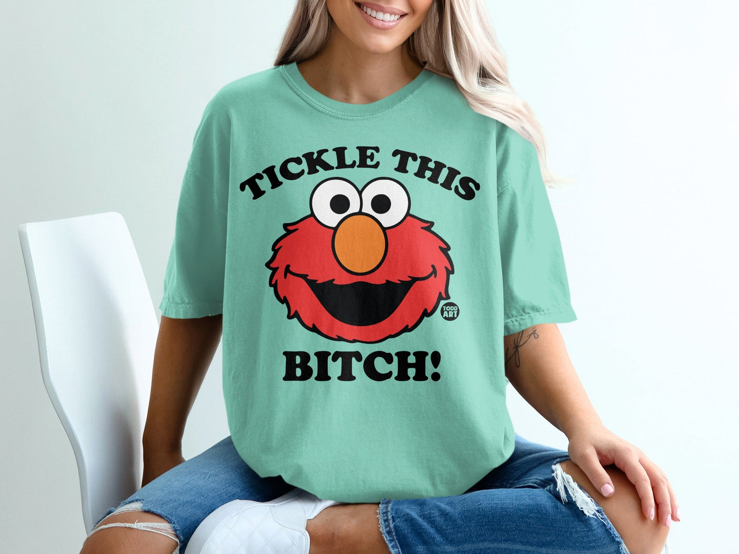 Mint t-shirt with Elmo graphic and text "TICKLE THIS BITCH!".