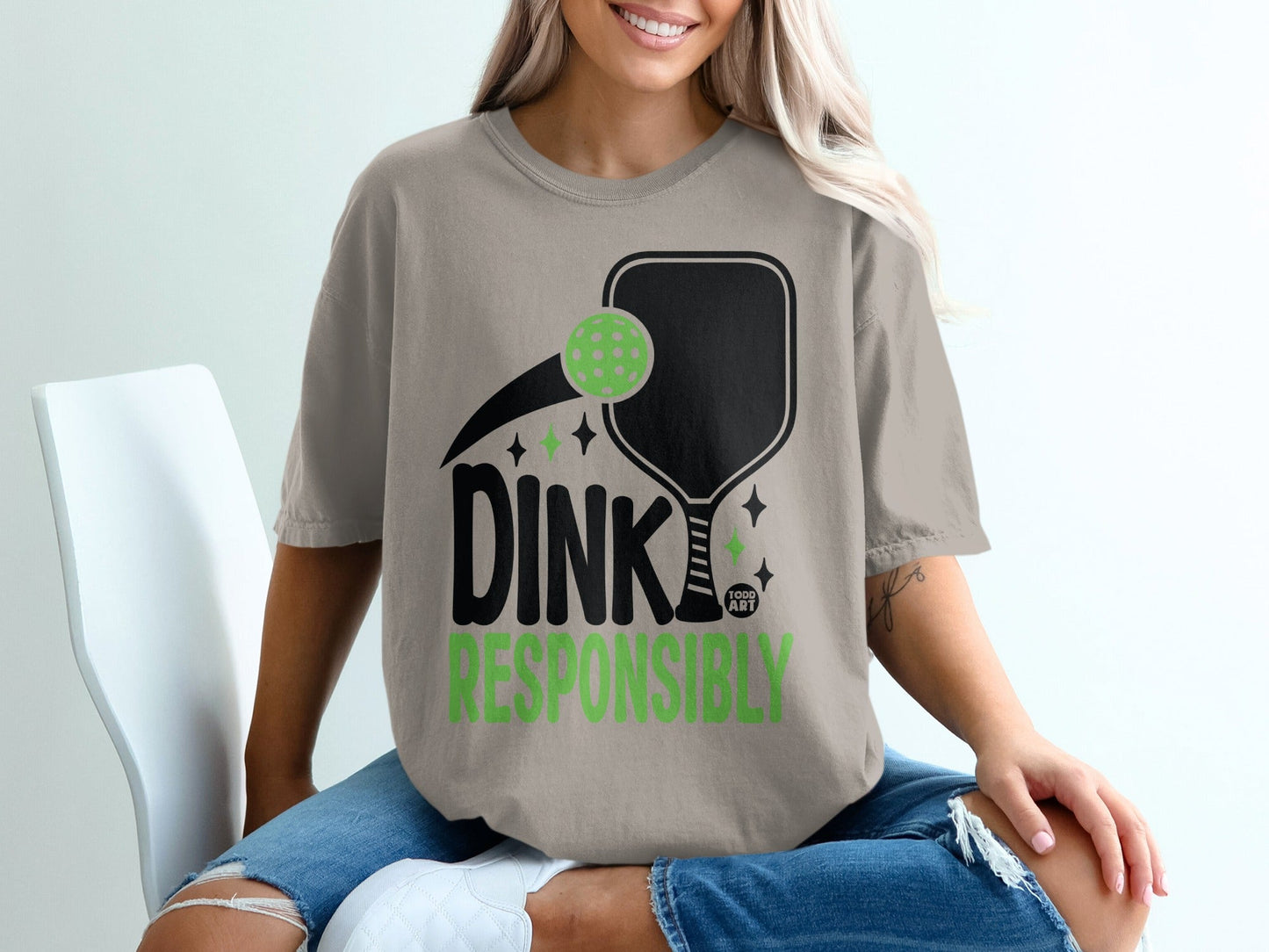 Green pickleball graphic with "DINK RESPONSIBLY" text on a tan t-shirt.