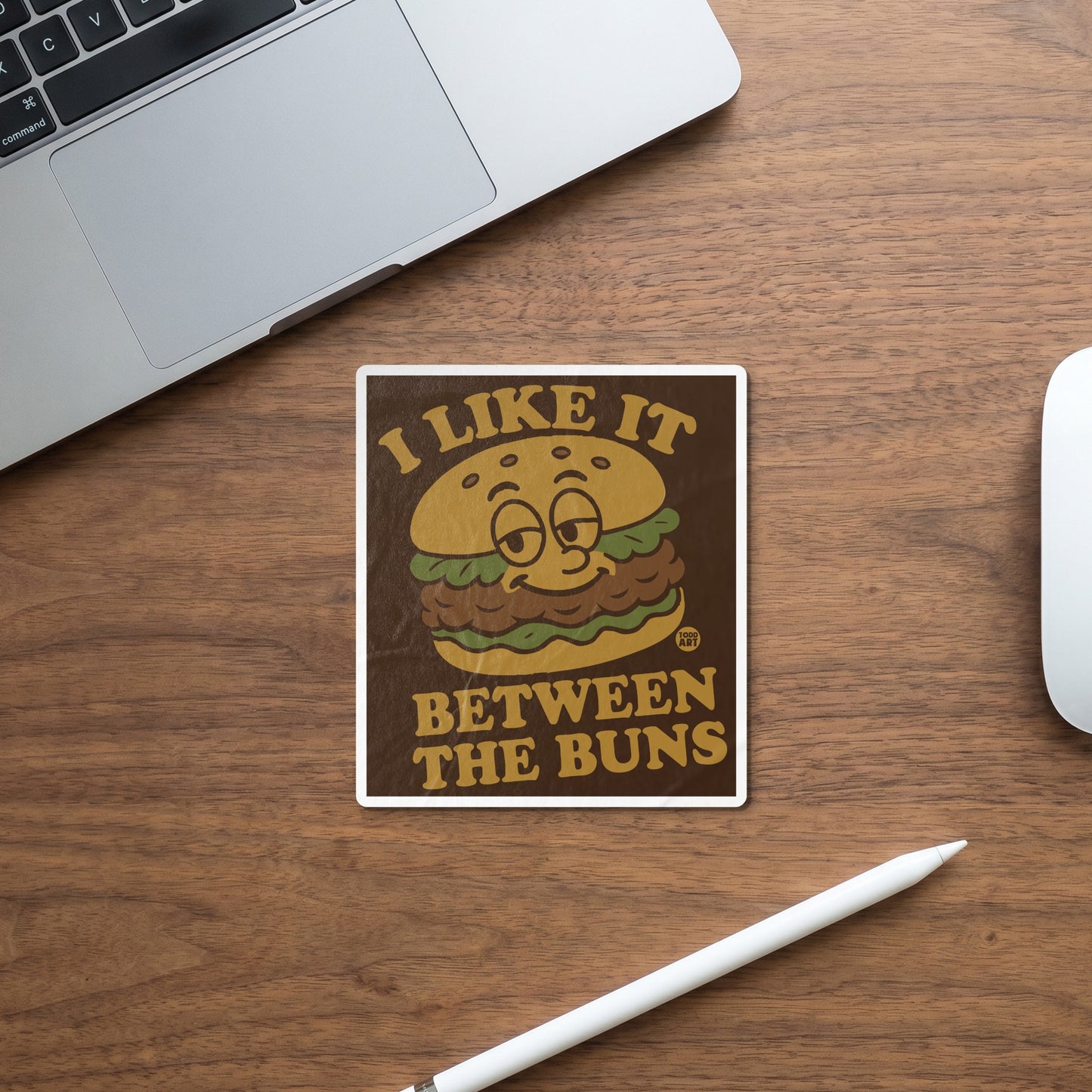 Sticker with a cartoon burger and text "I LIKE IT BETWEEN THE BUNS".