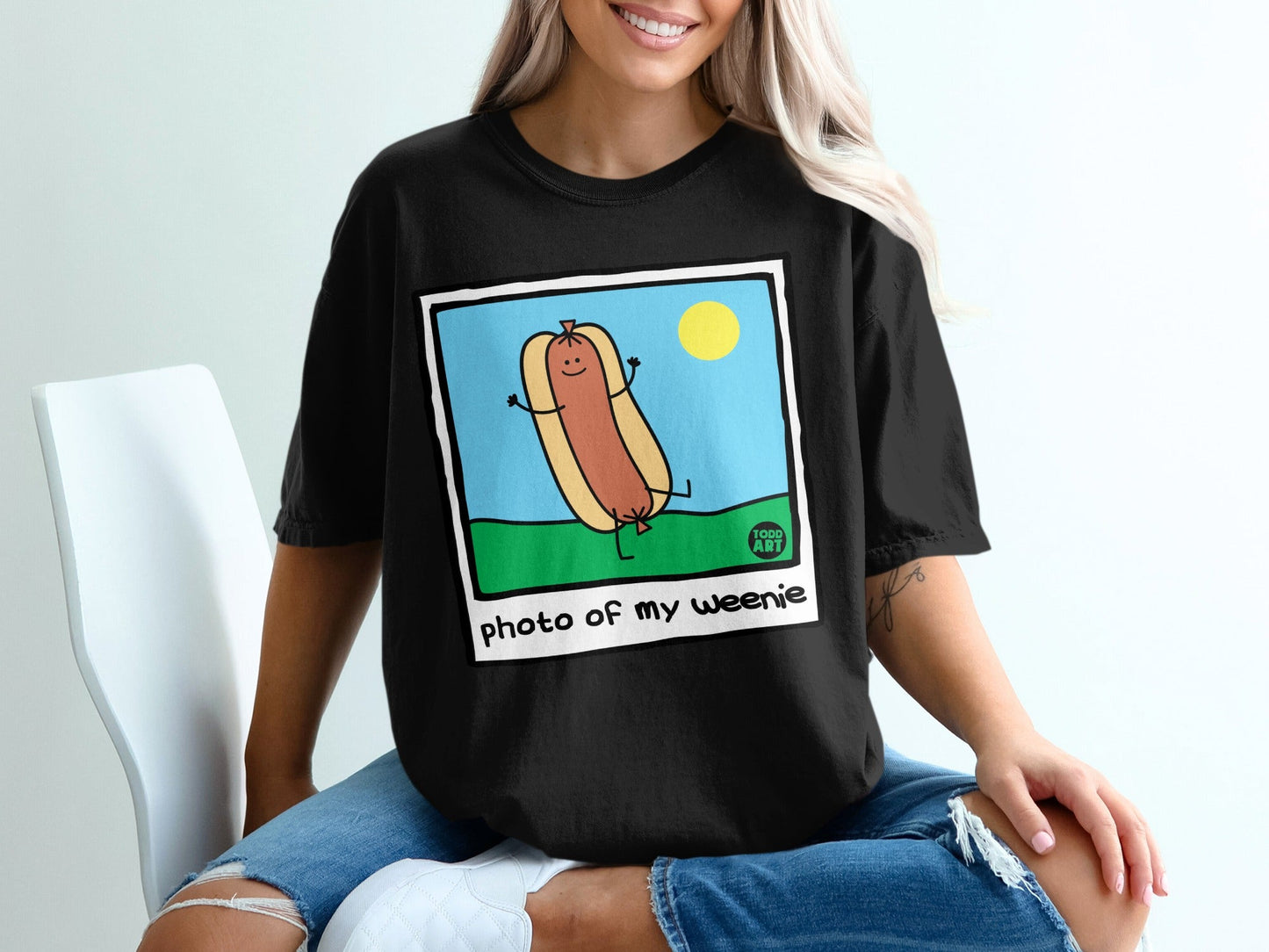 Black t-shirt with a cartoon hot dog and text "photo of my weenie".
