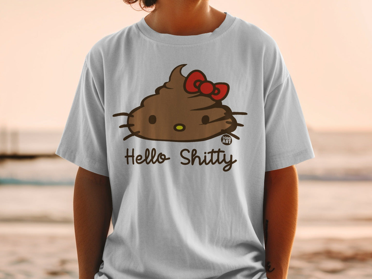White t-shirt featuring a brown Hello Kitty character with a red bow, smiling.