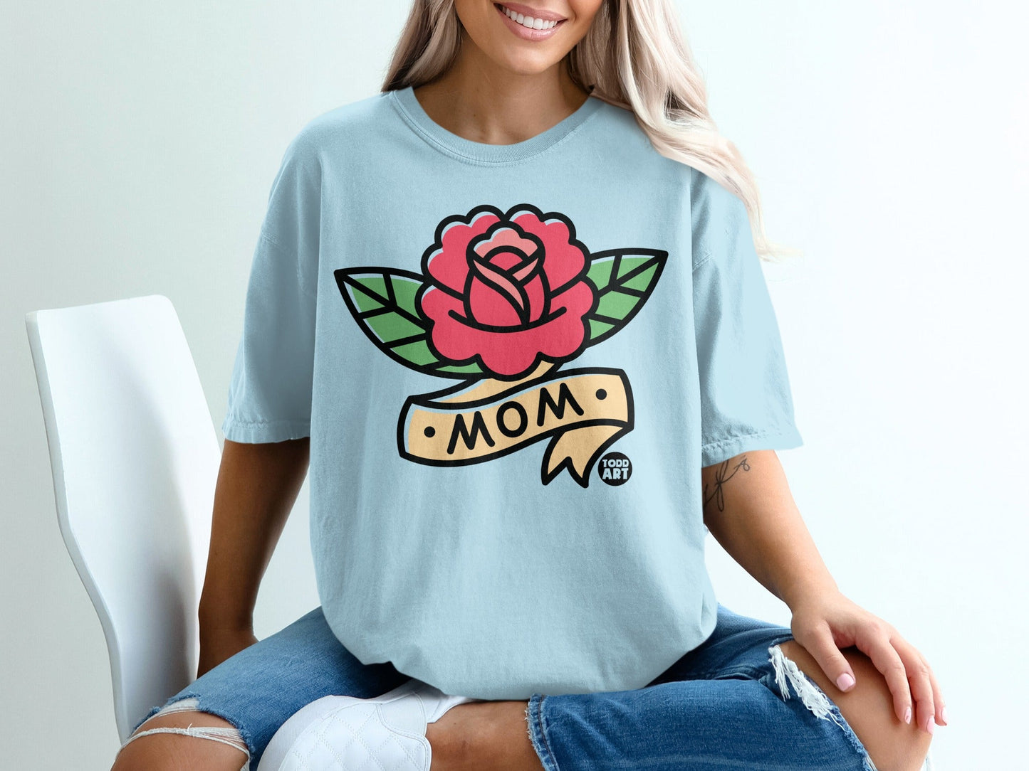 Light blue t-shirt with a red rose and "MOM" banner tattoo design.