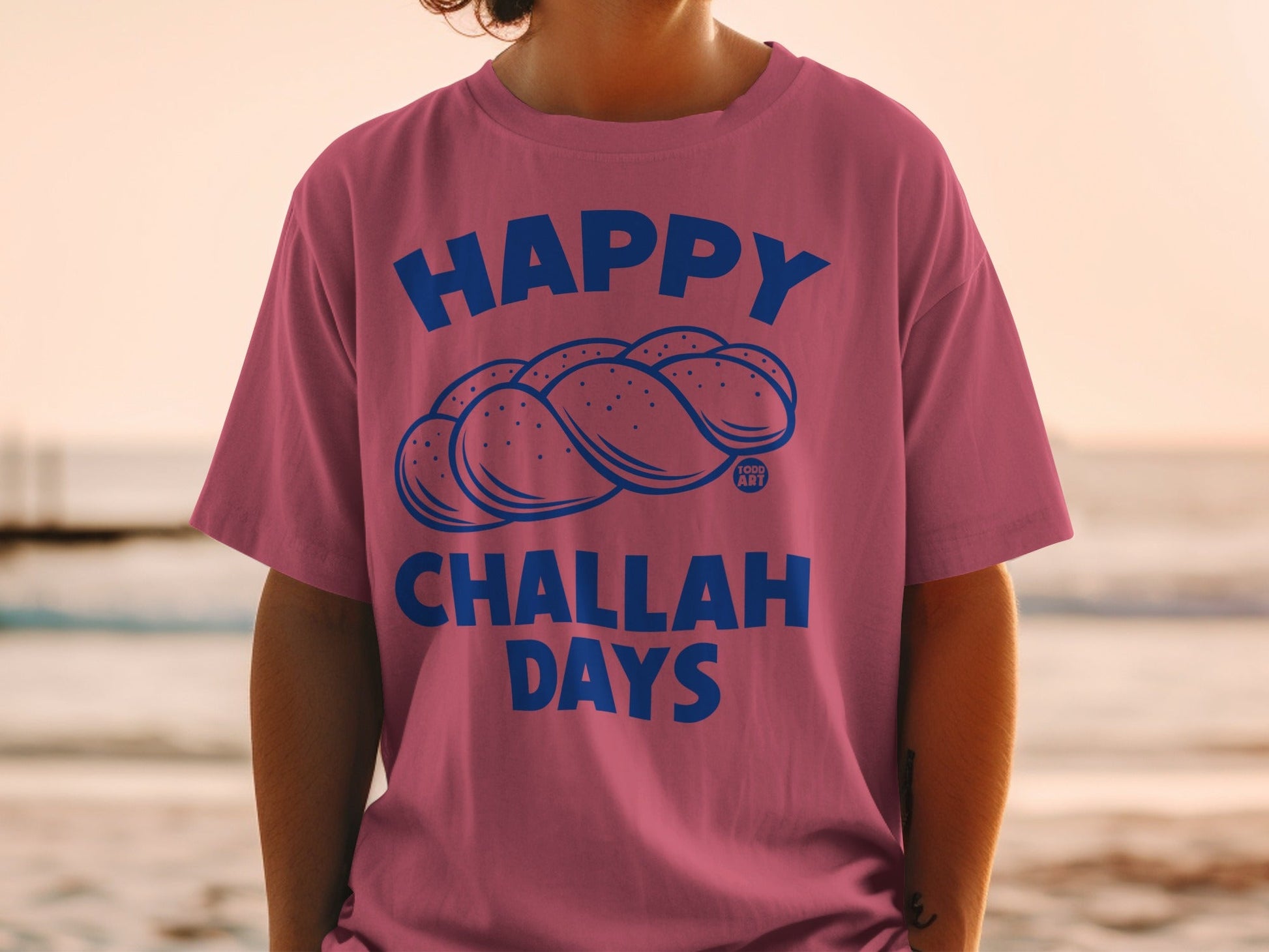 Pink t-shirt with "Happy Challah Days" and challah bread illustration.