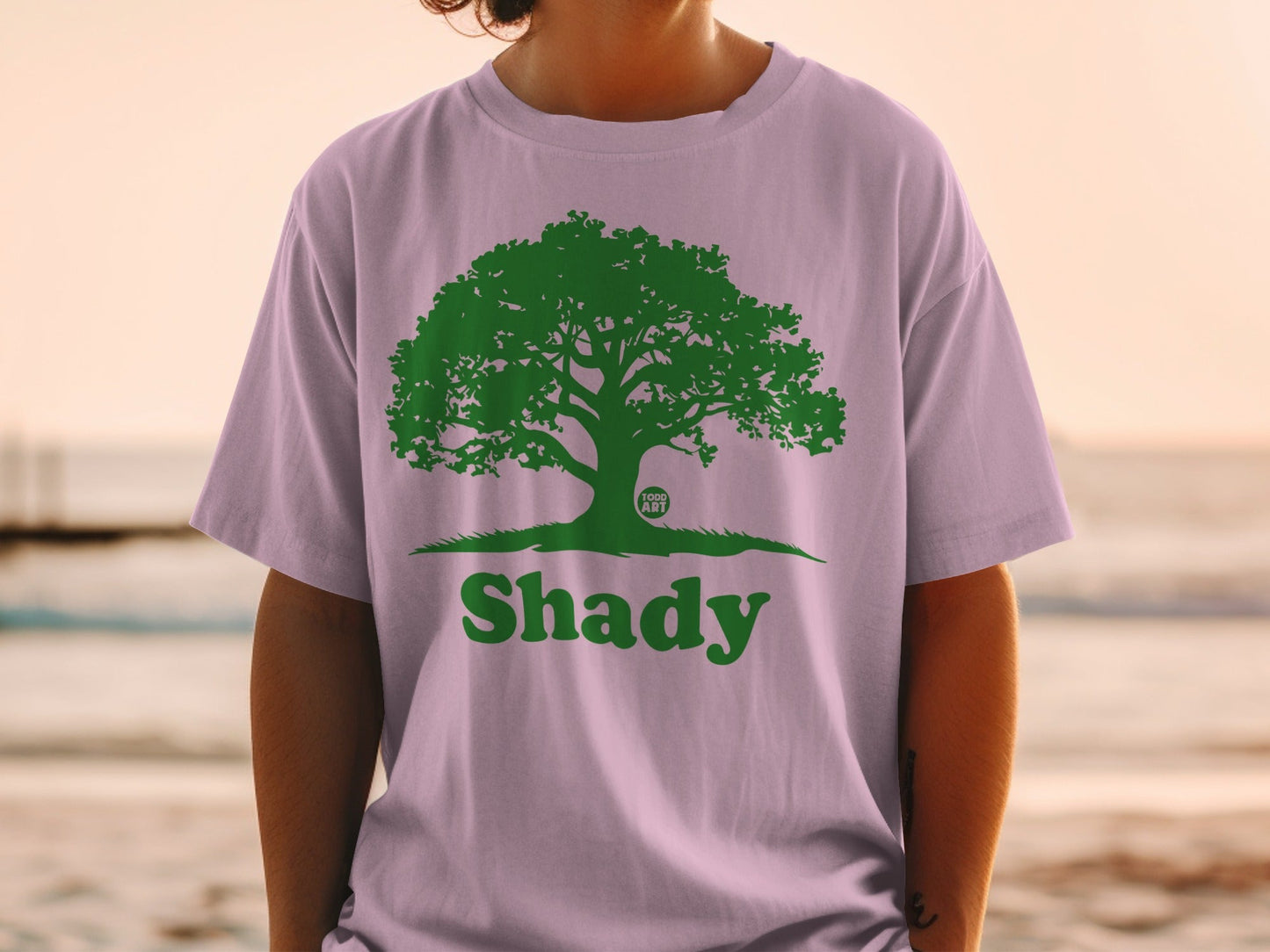 T-shirt with green tree logo and "Shady" text on a person.