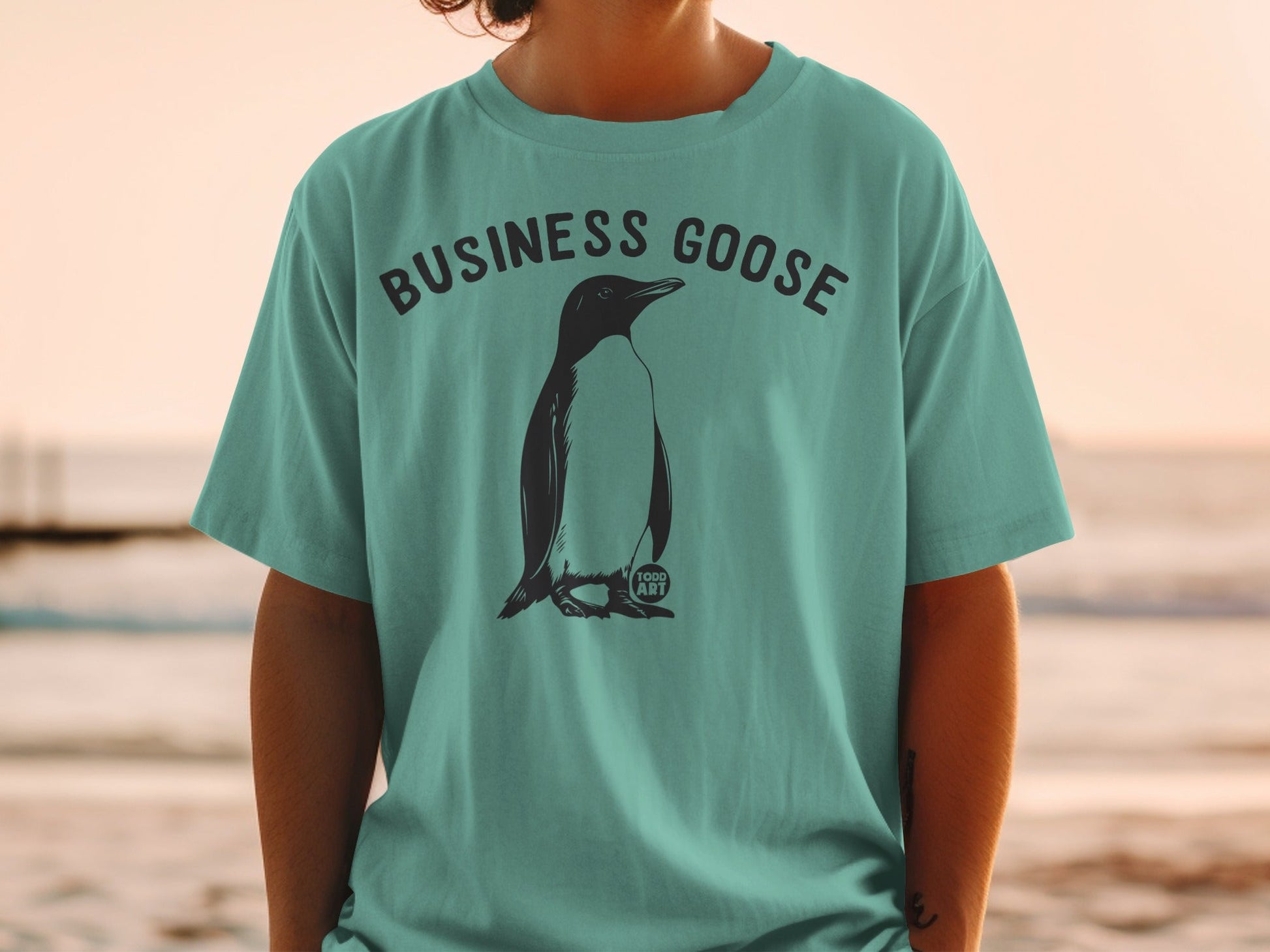 Teal t-shirt with "BUSINESS GOOSE" text and a penguin graphic.