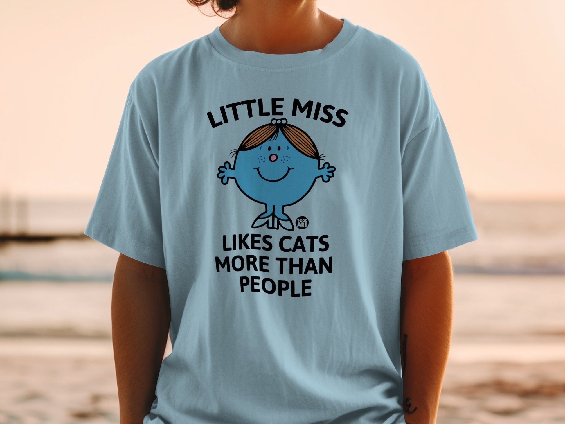Light blue t-shirt with Little Miss character and "Loves cats more than people" text.