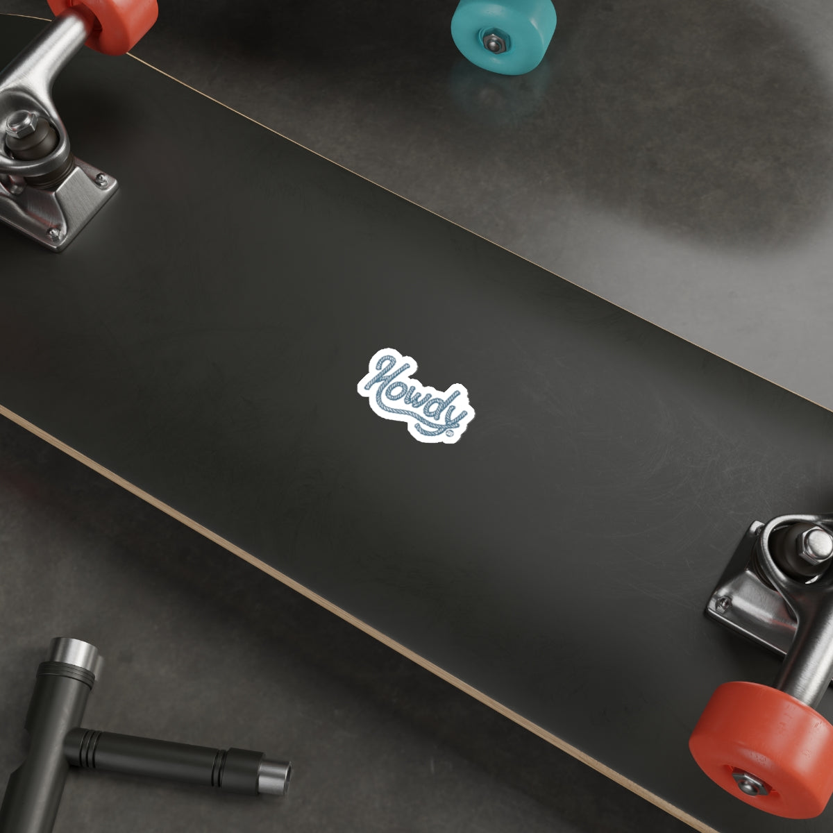 Howdy Sticker on Dark Skateboard Deck