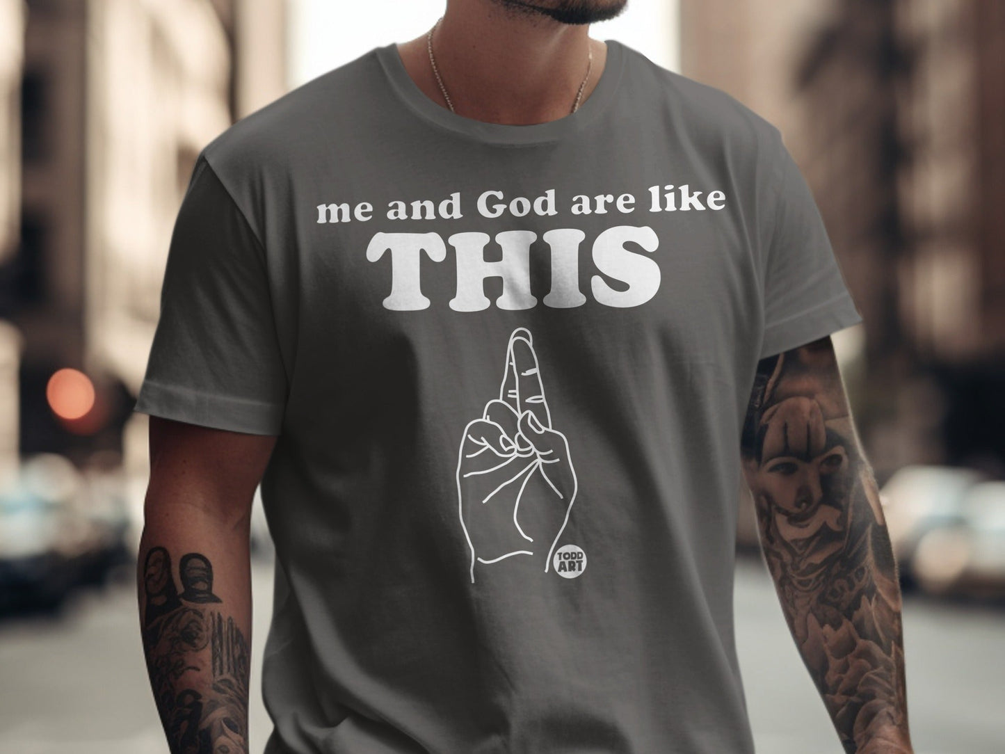 Grey t-shirt with "me and God are like THIS" text and a hand gesture.