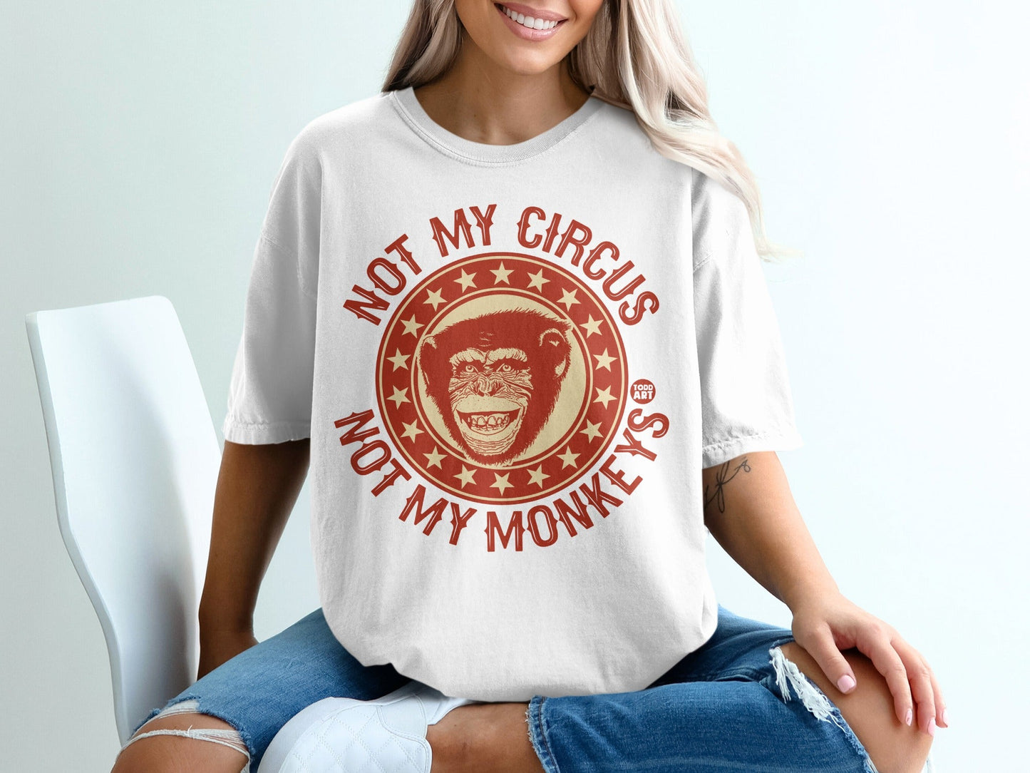 White t-shirt with red graphic of a monkey's face and text "NOT MY CIRCUS, NOT MY MONKEYS".