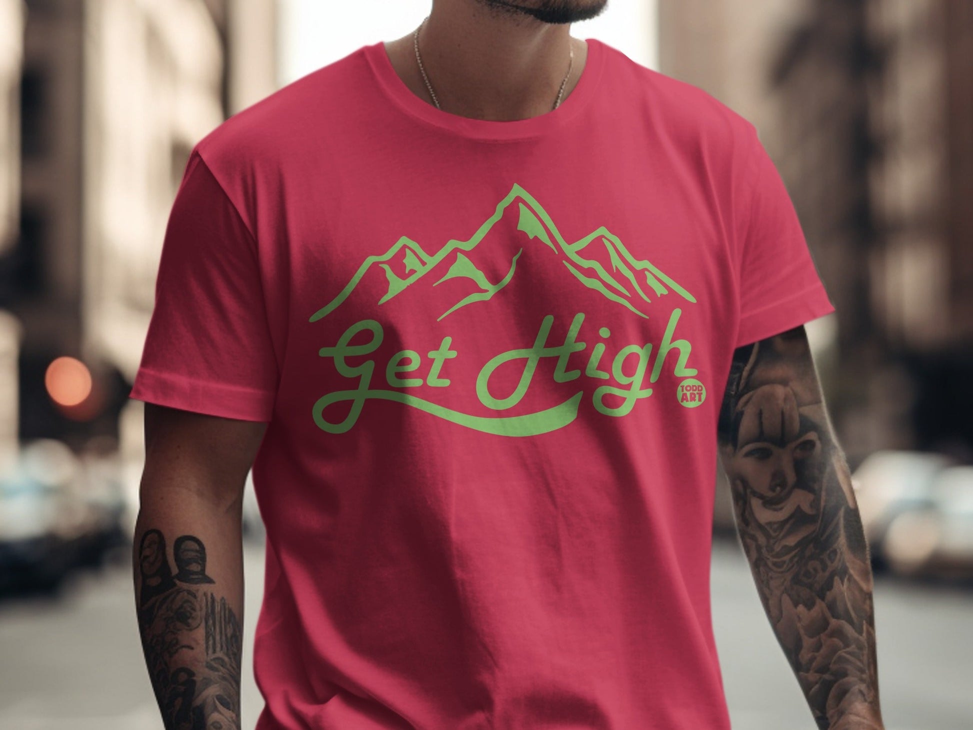 Red t-shirt with green "Get High" mountain graphic and tattoo.