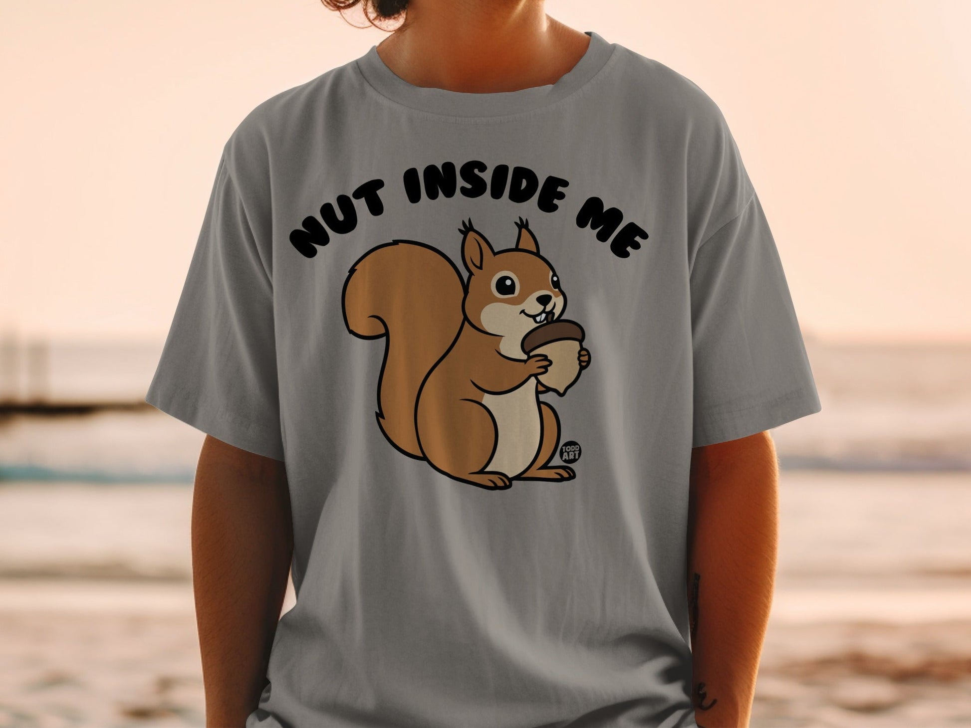 T-shirt with a cartoon squirrel holding an acorn, text "NUT INSIDE ME".