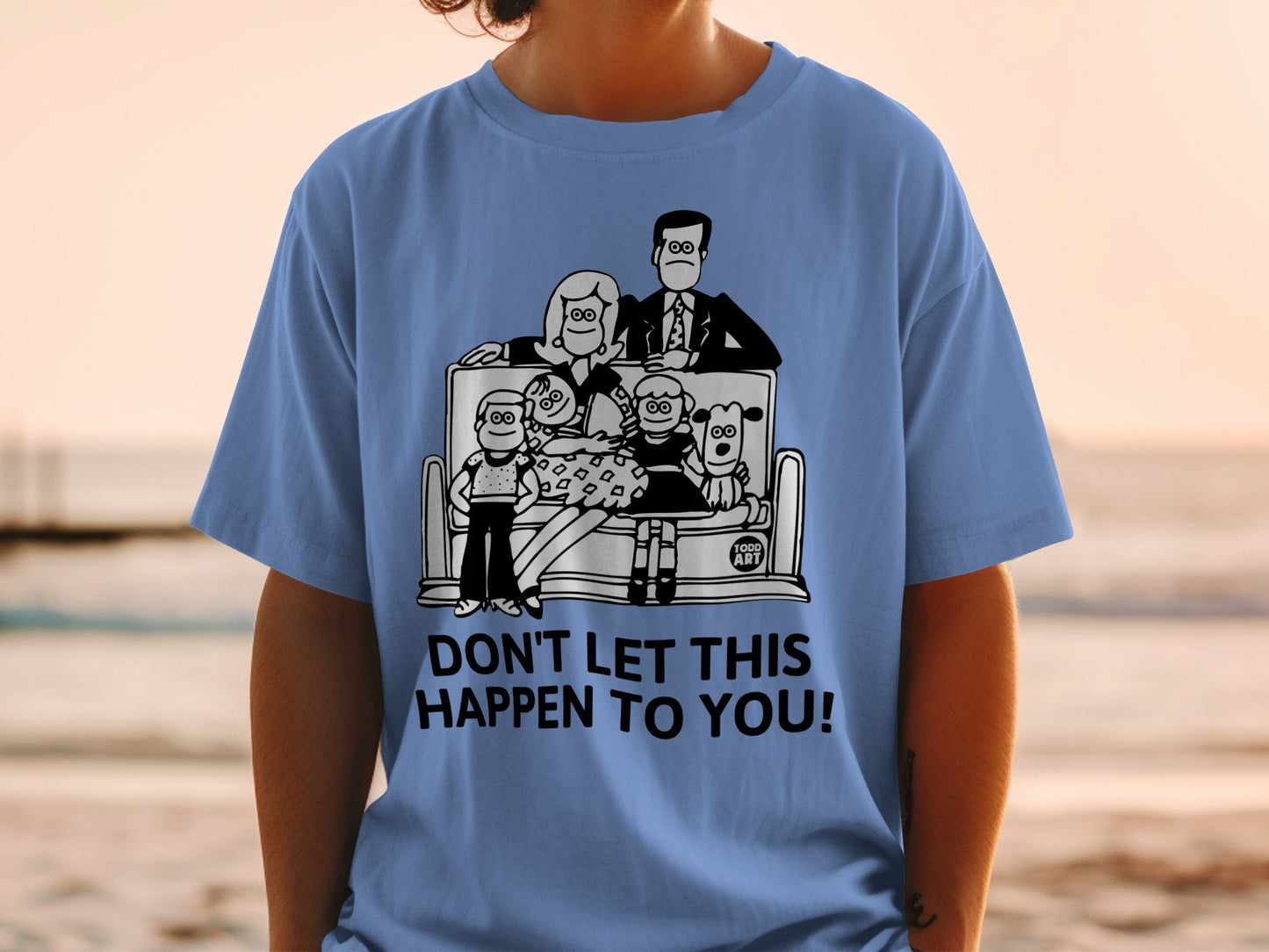 Blue t-shirt with cartoon family on bench and text "DON'T LET THIS HAPPEN TO YOU!".