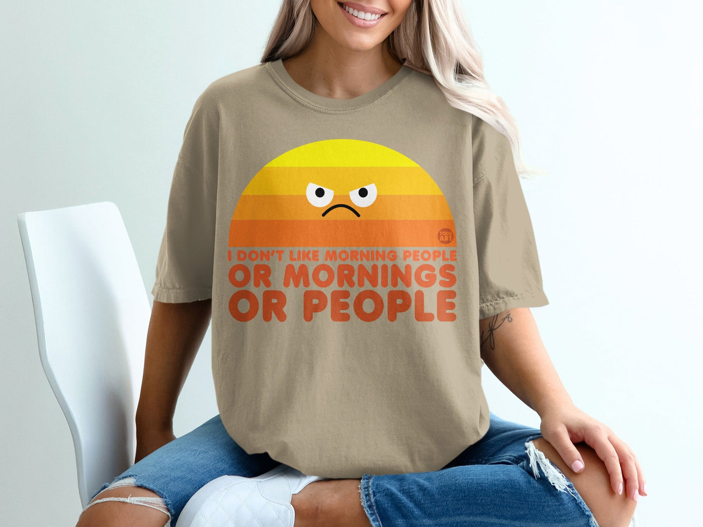 Tan t-shirt with a grumpy sun graphic and "I DON'T LIKE MORNING PEOPLE OR MORNINGS" text.