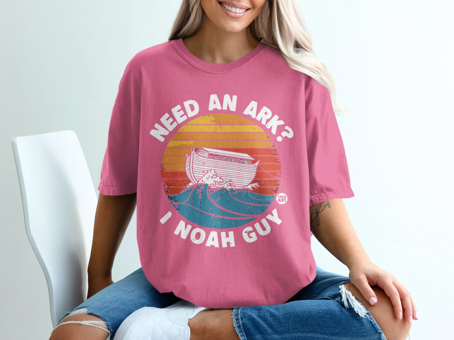 Pink t-shirt with "NEED AN ARK? I NOAH GUY" and Noah's Ark on waves.
