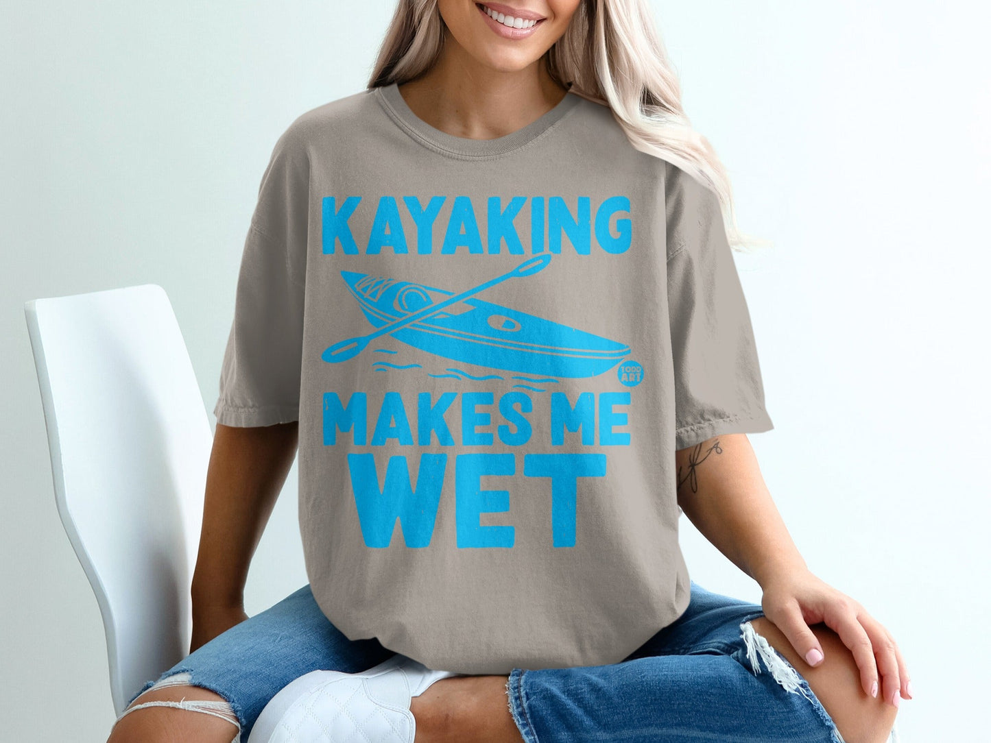 T-shirt with blue text "Kayaking Makes Me Wet" and a kayak graphic.