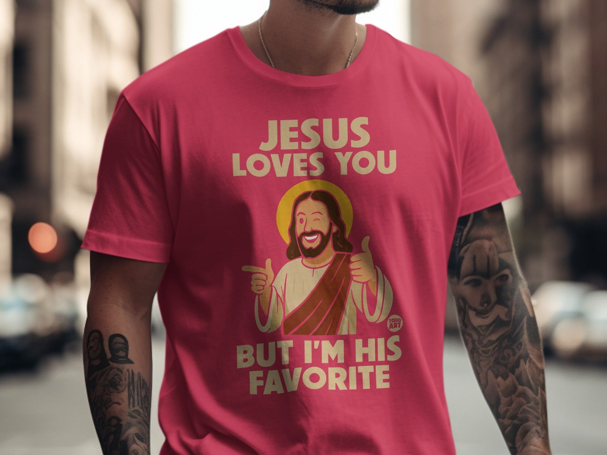 Pink t-shirt with "Jesus Loves You But I'm His Favorite" text and cartoon Jesus.