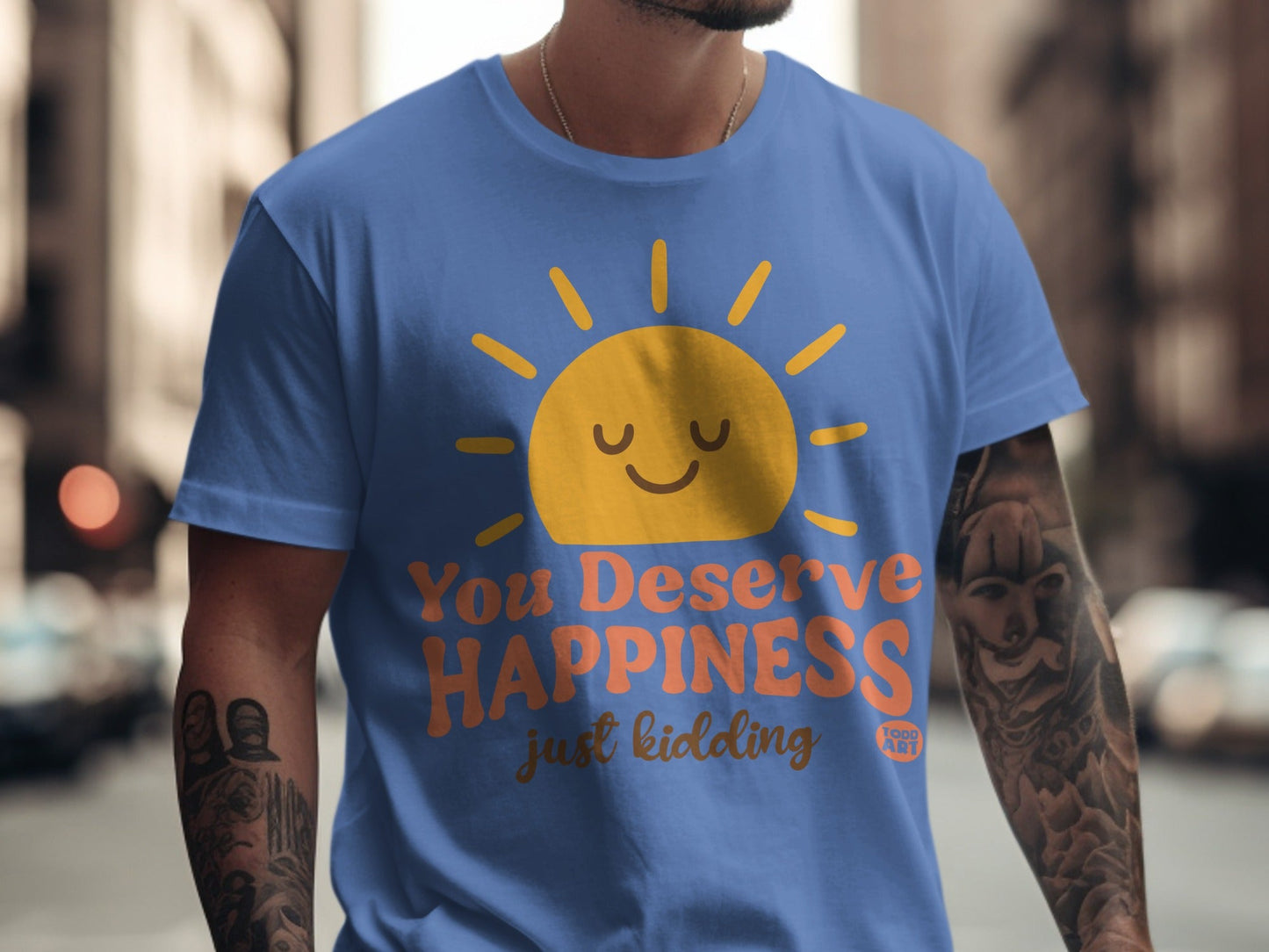 Blue t-shirt with a smiling sun and "You Deserve Happiness just kidding" text.