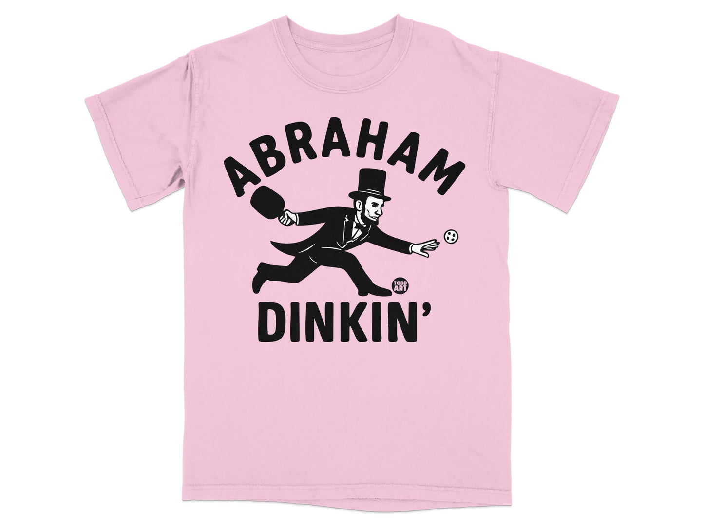 Pink t-shirt with Abraham Lincoln playing pickleball graphic.