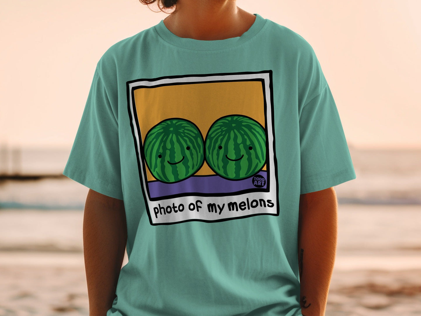 T-shirt with two smiling watermelons on a beach, "photo of my melons" text.