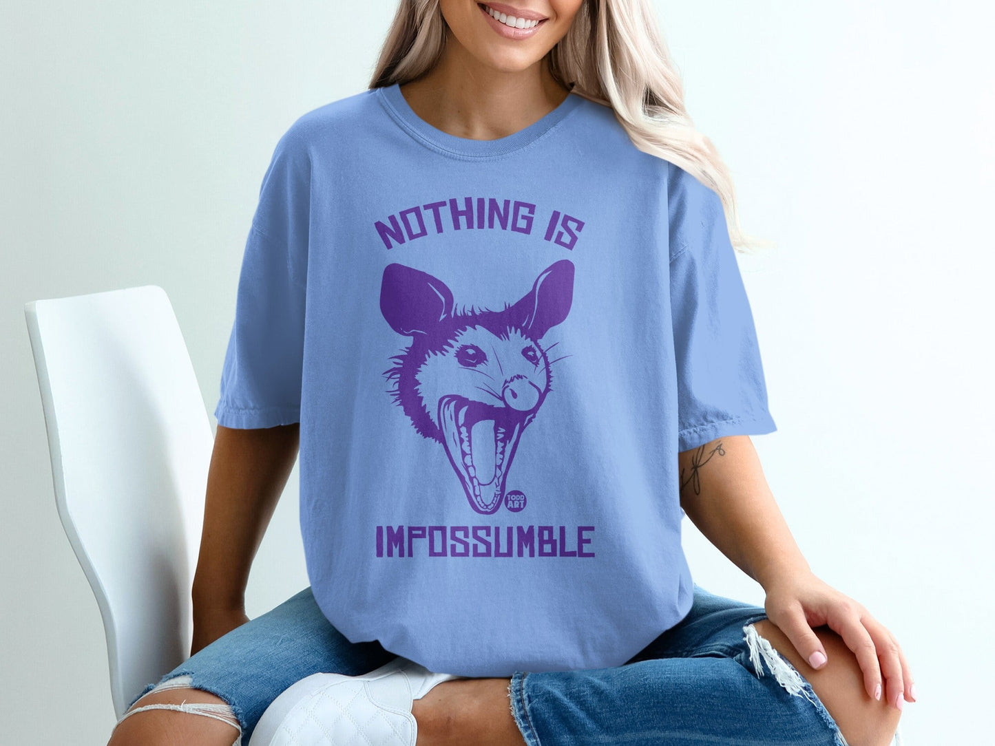 Purple t-shirt with purple text "NOTHING IS IMPOSSUMBLE" and a cartoon possum.